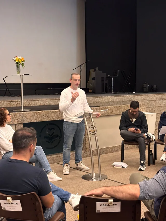 Participantes de um encontro reunidos ao redor de uma exposição
