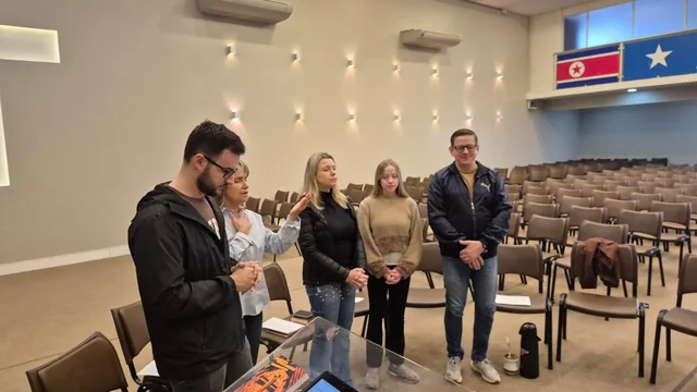 Grupo reunido em pé no auditório